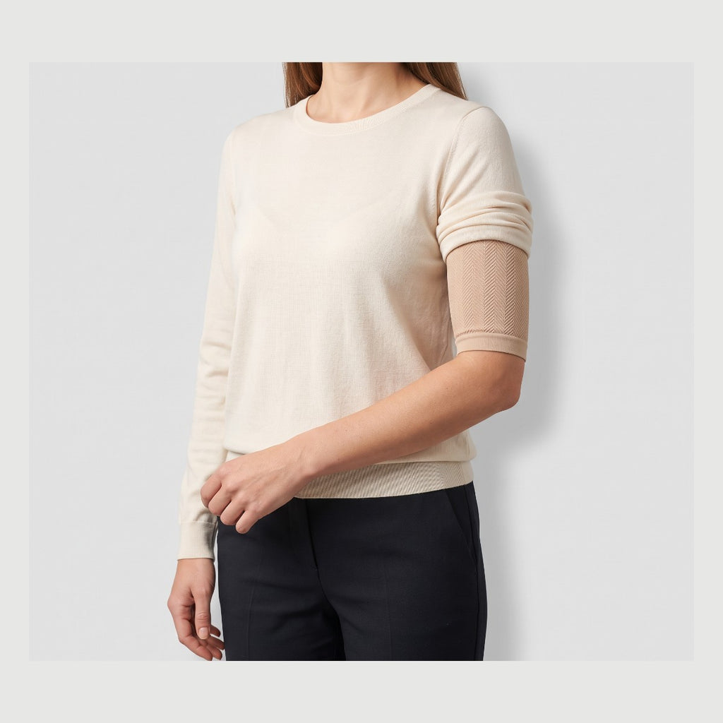 Woman wearing a beige smoothing arm sleeve under a short-sleeve top