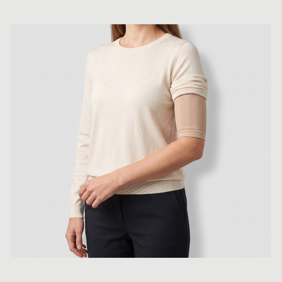 Woman wearing a beige smoothing arm sleeve under a short-sleeve top