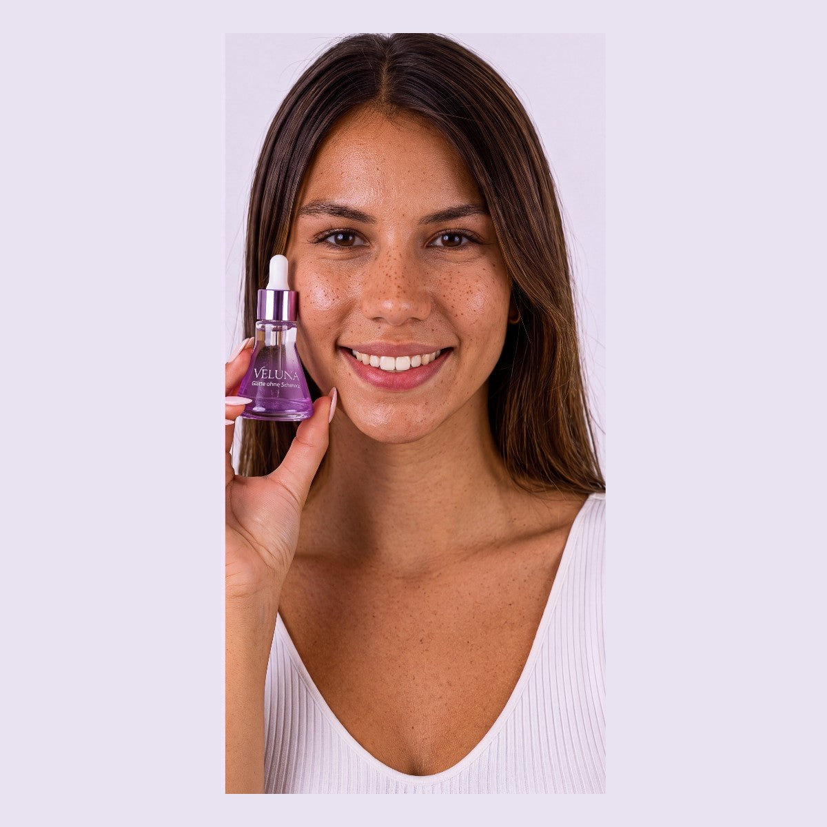 Smiling woman holding Veluna serum bottle