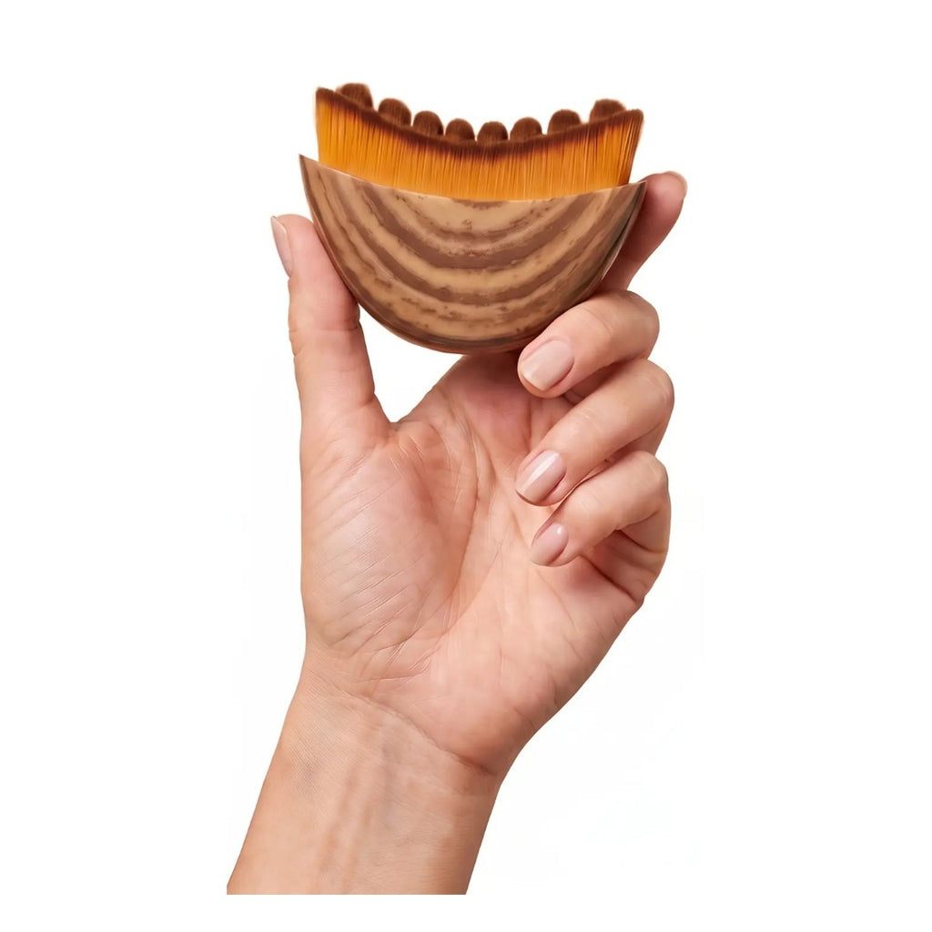 Hand holding the soft-bristle face brush