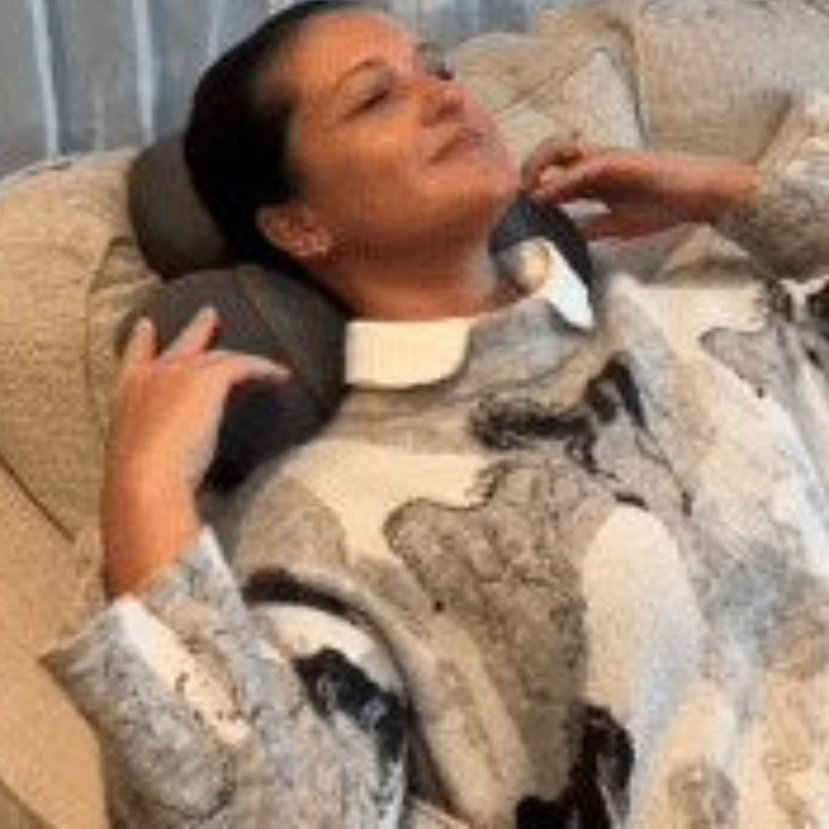 Woman relaxing on the sofa with the neck stretcher pillow
