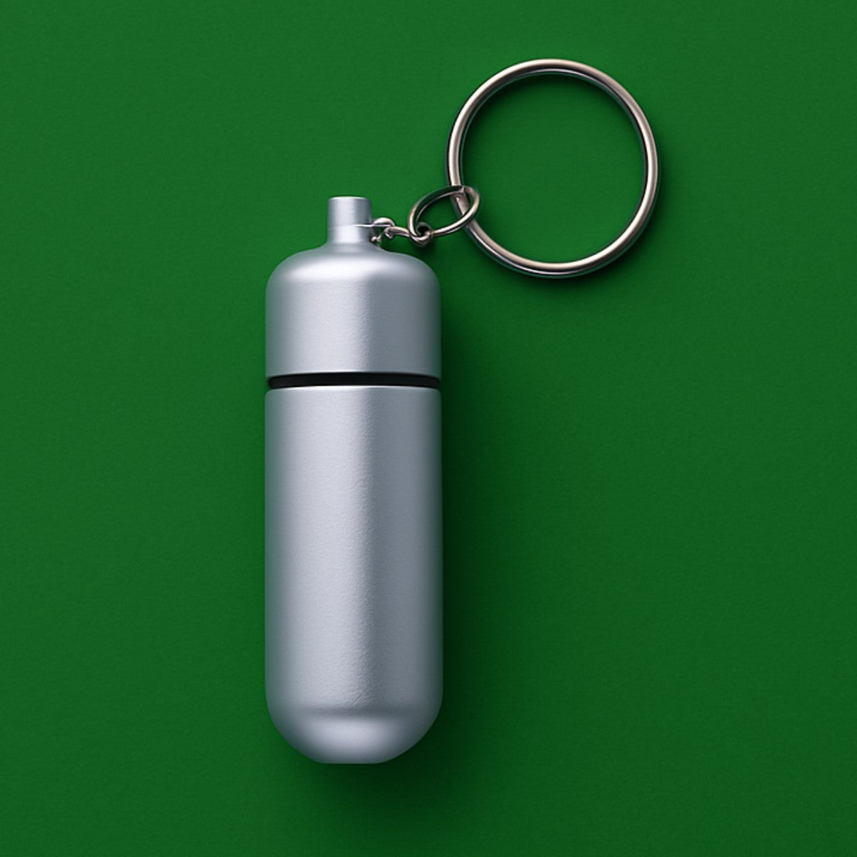 Silver keychain pill case with key ring, close-up