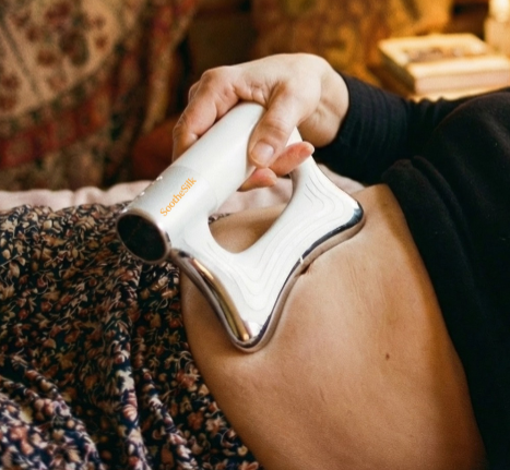 Woman gliding the contoured massager over her thigh